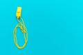 Plastic yellow whistle on turquoise blue background Royalty Free Stock Photo