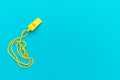 Plastic yellow whistle on turquoise blue background Royalty Free Stock Photo