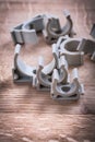 Plastical fixators for water pipes on wooden board Royalty Free Stock Photo