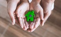 Plasticine clay house on child and parents hands.Happy family and warm house concept