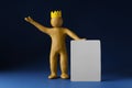 Plasticine figure with crown on head holding blank sign against dark blue background Royalty Free Stock Photo