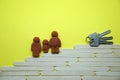 Plasticine figurines of a man, a woman and a child on the stairs leading to the keys, the concept of buying a house