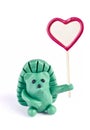 Plasticine hedgehog retaining heart-shaped banner Royalty Free Stock Photo