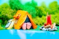 Plasticine landscape with a tent, a campfire and a backpack in the middle of the forest