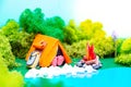 Plasticine landscape with a tent, a campfire and a backpack in the middle of the forest