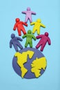 Plasticine multicolored cartoon people on globe. The use and depletion of the planet earth, overpopulation and population growth Royalty Free Stock Photo