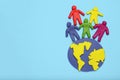 Plasticine multicolored cartoon people on globe. The use and depletion of the planet earth, overpopulation and population growth