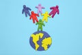 Plasticine multicolored cartoon people on globe. The use and depletion of the planet earth, overpopulation and population growth