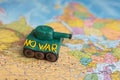 A plasticine tank on the background of a world map, as a symbol of peace and goodness. There is no war appeal. Stop war