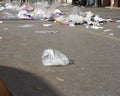 Plastics waste flying on city pavement loaded with overconsumption trash Royalty Free Stock Photo