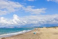 A Sardinian fisherman with a rod on Plata Mona Beach, Sardinia, Italy. The photo captures the beach, distant mountains, and Royalty Free Stock Photo