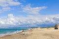 A Sardinian fisherman with a rod on Plata Mona Beach, Sardinia, Italy. The photo captures the beach, distant mountains, and Royalty Free Stock Photo