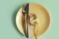 Plate alarm clock, measuring tape table dinner on a color background