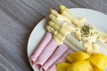 Plate with asparagus potatoes and ham with sauce hollandaise