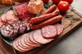 Plate with assortment of delicious deli meats on wooden board Royalty Free Stock Photo