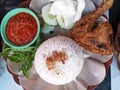 A plate of Ayam Goreng, an Indonesian popular dish that consists of rice, fried chicken, vegetables, and tomato sauce. Royalty Free Stock Photo