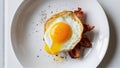 A plate of bacon and egg with a yolk on top Royalty Free Stock Photo