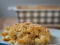 Plate of baked macaroni and cheese in front of a casserole dish Royalty Free Stock Photo