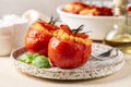 A plate with baked stuffed tomatoes with rice, cheese and basil.