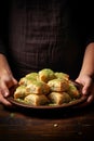 a plate of baklava in the hands of the cook. Selective focus.