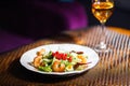 A plate with a beautiful appetizing salad of fresh vegetables, shrimps, quail eggs and lingonberries is on the table with a wine Royalty Free Stock Photo