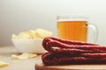 Plate with beer snacks, potatoes chips, meat sausages. Pork or beef sausage with beer
