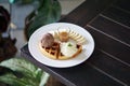 A plate of Belgian waffle with banana and caramel sauce, topped with whipped cream and ice cream Royalty Free Stock Photo