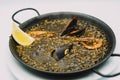 plate of black rice paella with squid, shrimp and mussels Royalty Free Stock Photo