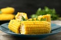 Plate of boiled corn cobs with parsley on wooden table Royalty Free Stock Photo
