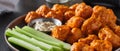 Plate of boneless chicken wings with buffalo sauce and celery sticks Royalty Free Stock Photo