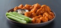 Plate of boneless chicken wings with buffalo sauce and celery sticks Royalty Free Stock Photo