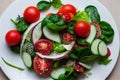 Plate with bright appetizing green salad and small red tomatoes.
