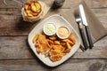 Plate with British traditional fish and potato chips on background, top view Royalty Free Stock Photo