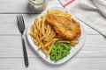 Plate with British traditional fish and potato chips on wooden background Royalty Free Stock Photo