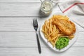 Plate with British traditional fish and potato chips on wooden background, top view. Royalty Free Stock Photo