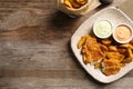 Plate with British traditional fish and potato chips on wooden background, top view. Royalty Free Stock Photo