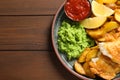 Plate with British traditional fish and potato chips on wooden background, top view. Royalty Free Stock Photo