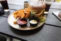 Plate with burger and french fries, ketchup and mayonnaise and cola on the table. Royalty Free Stock Photo