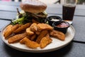 Plate with burger and french fries, ketchup and mayonnaise and cola on the table. Royalty Free Stock Photo