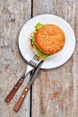 Plate with burger on wood.