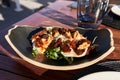 Plate of burrata salad on wooden surface