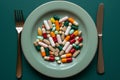 Plate with capsules and pills, spoon and knife on wood table. Royalty Free Stock Photo