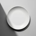 The plate casts a distinct shadow due to the angled lighting from the top left Royalty Free Stock Photo