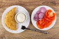 Plate with cheburek, bowl with mayonnaise, plate with slices of tomato, red onion, fork on table. Top view Royalty Free Stock Photo