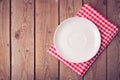 Plate on checked tablecloth over wooden background. View from above Royalty Free Stock Photo