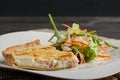 Plate of cheese and potpie with meat and salad