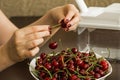 Plate. cherries. Removal cherry. hands Royalty Free Stock Photo