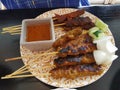 A plate of chicken and beef satay