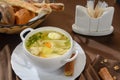 A plate of chicken soup with egg and herbs.