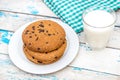 Plate with chocolate chip cookies, glass of milk and kitchen towel on the old blue wooden table Royalty Free Stock Photo